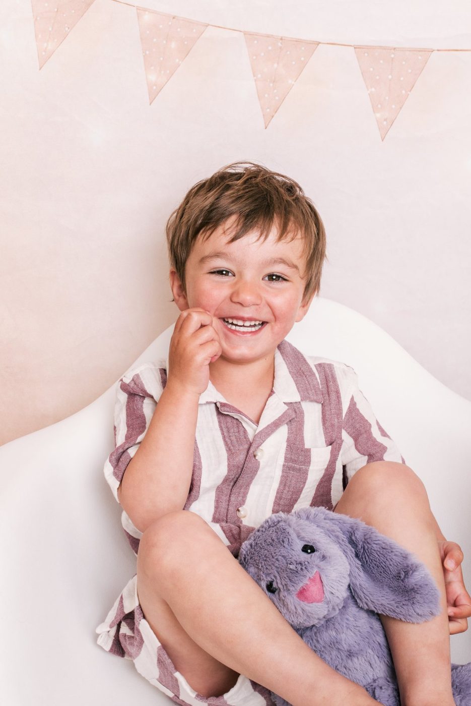A little boy laughing with his toy bunny