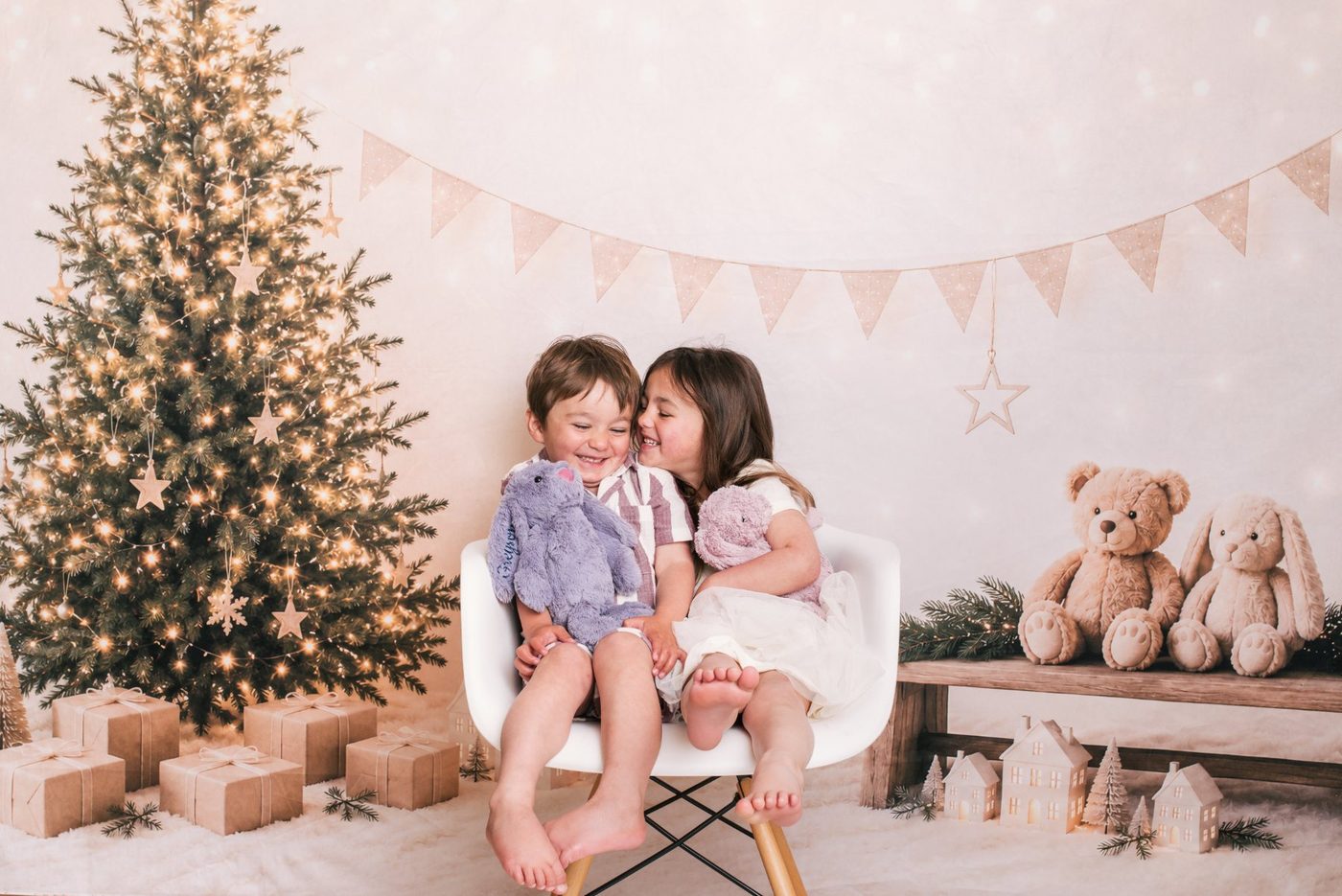 Siblings laughing together at a Little Portrait Club Christmas session