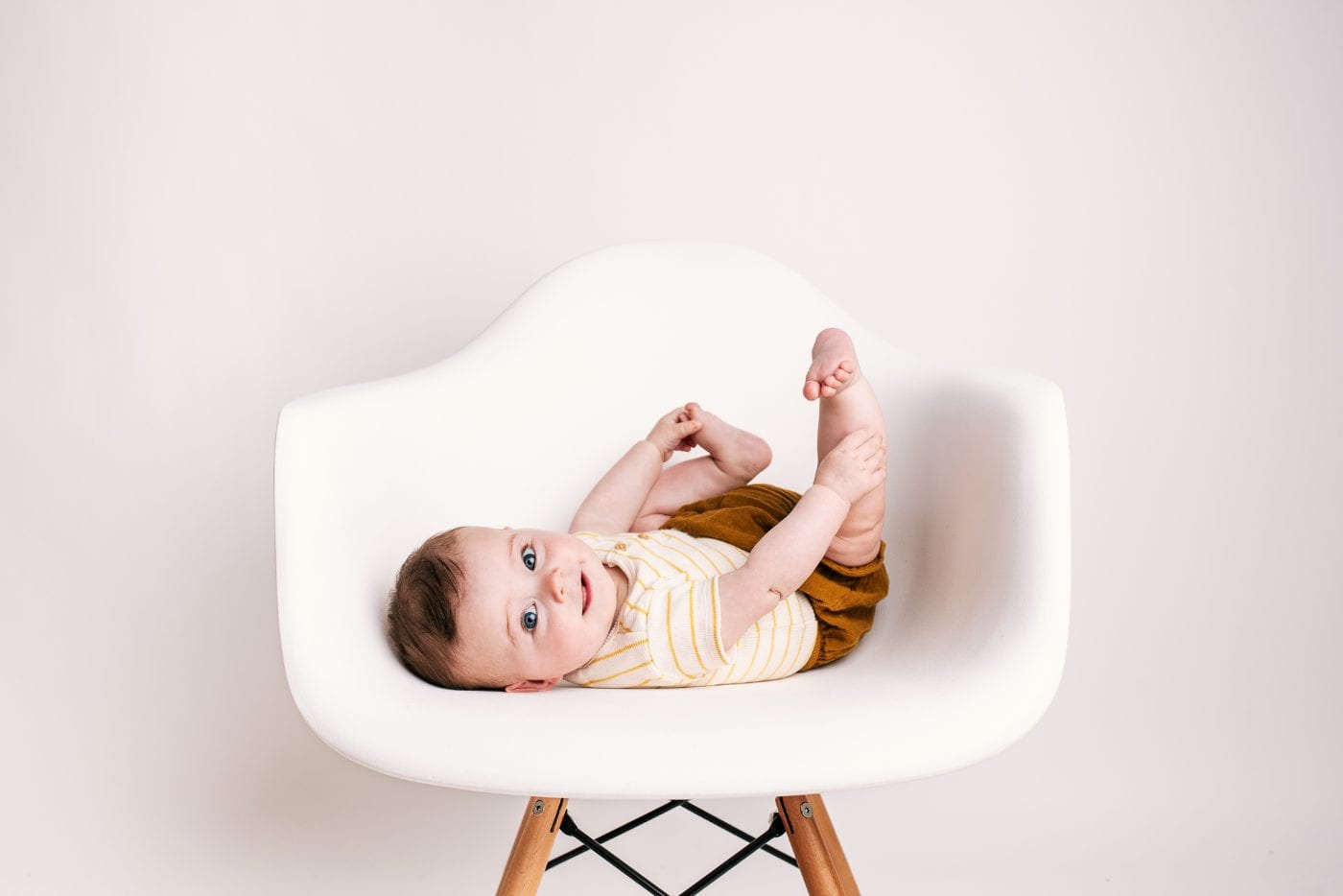 Sitting up and grabbing her own feet.