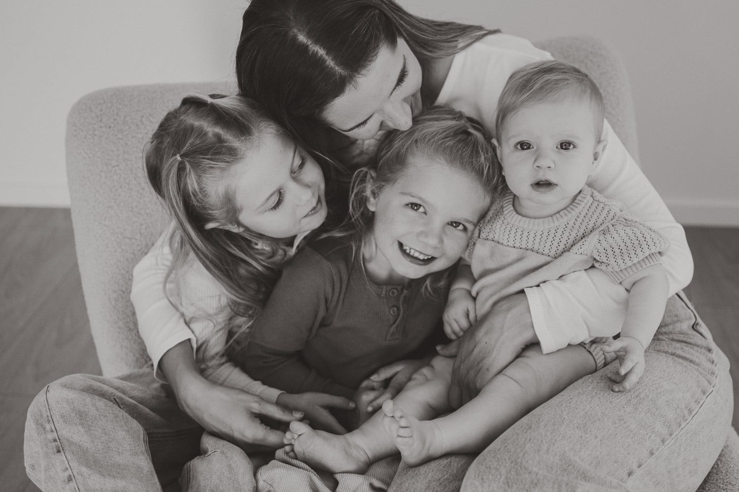 A mother with her four children in a black and white studio portrait