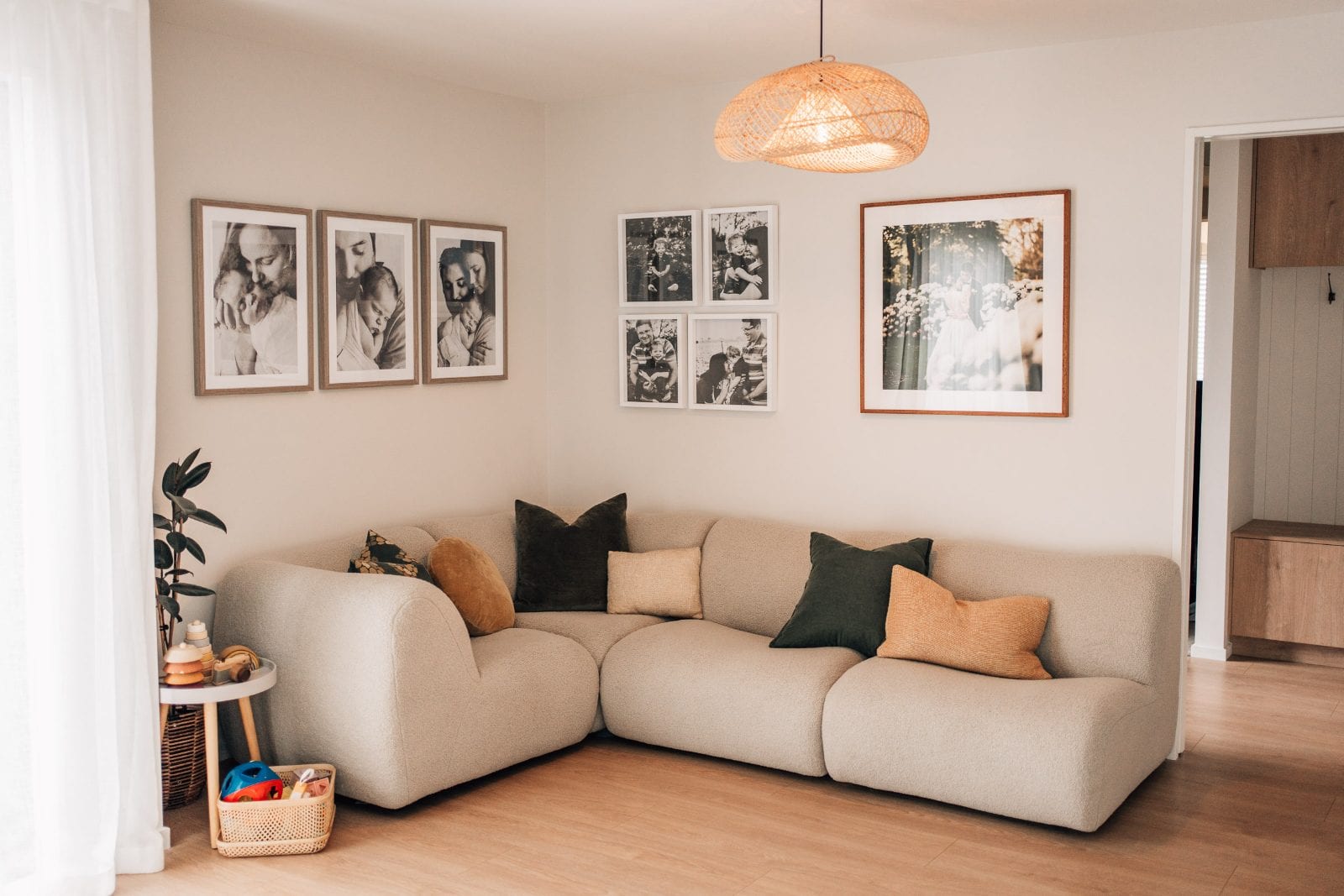 Cosy boucle sofa below a black-and-white family gallery wall in the lounge of our Lincoln, Canterbury portrait studio.