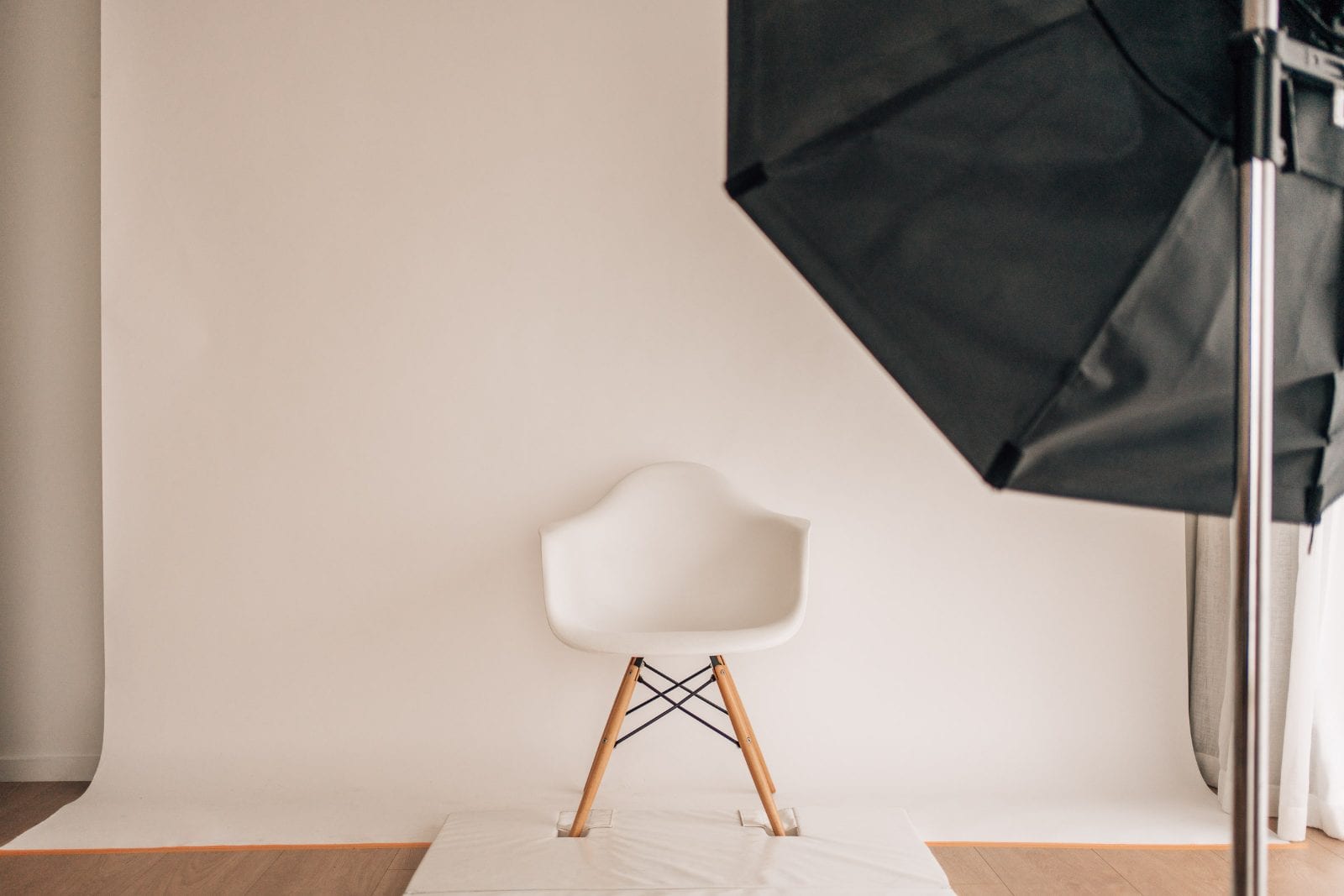 White studio backdrop with a moulded chair and softbox lighting in the shooting area of our Lincoln, Canterbury portrait studio.