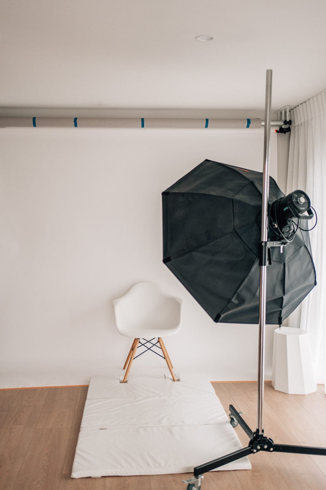 White paper backdrop with a softbox light and posing chair set up in the shooting space of our Lincoln, Canterbury portrait studio.