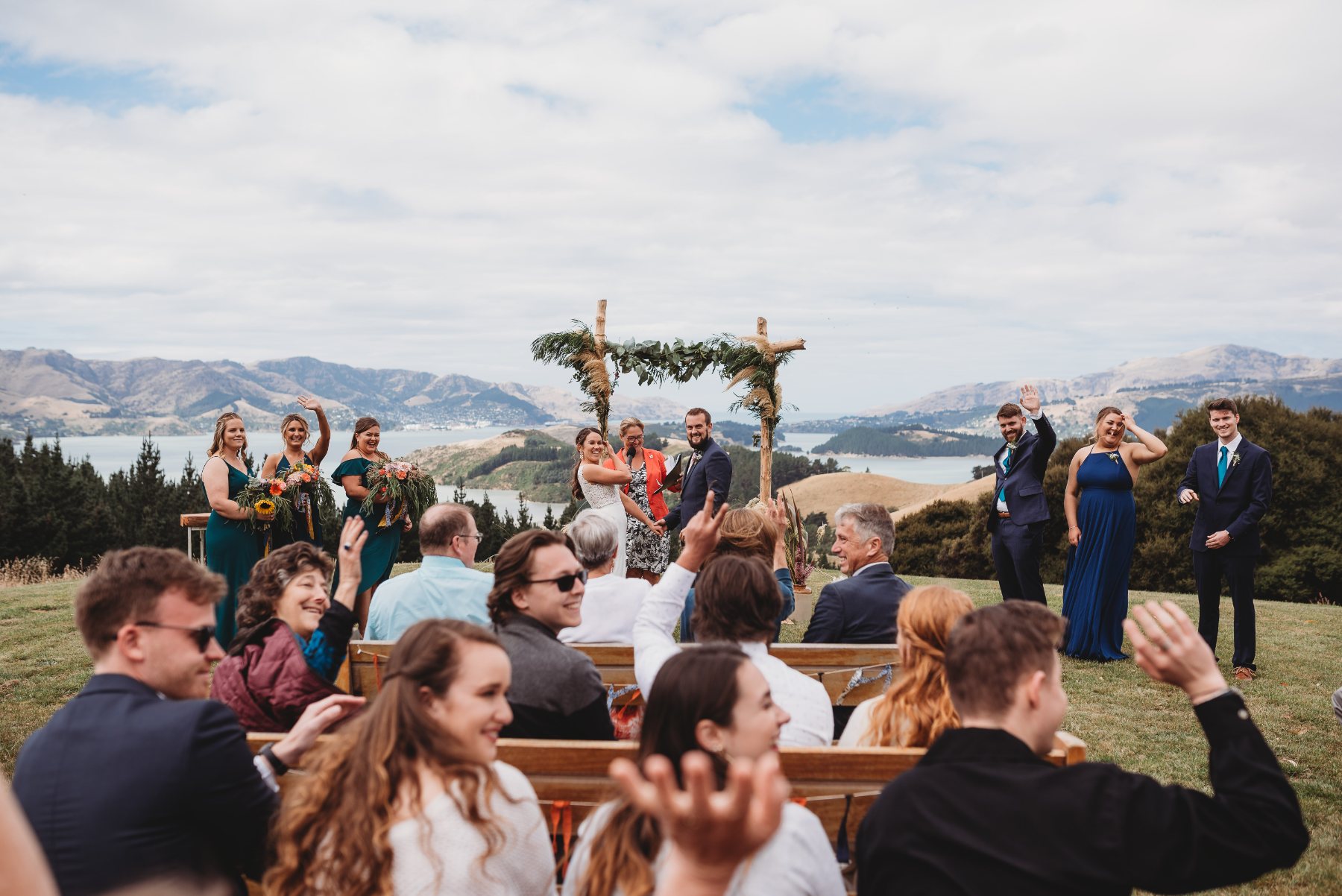 Guests waving during a hilltop ceremony