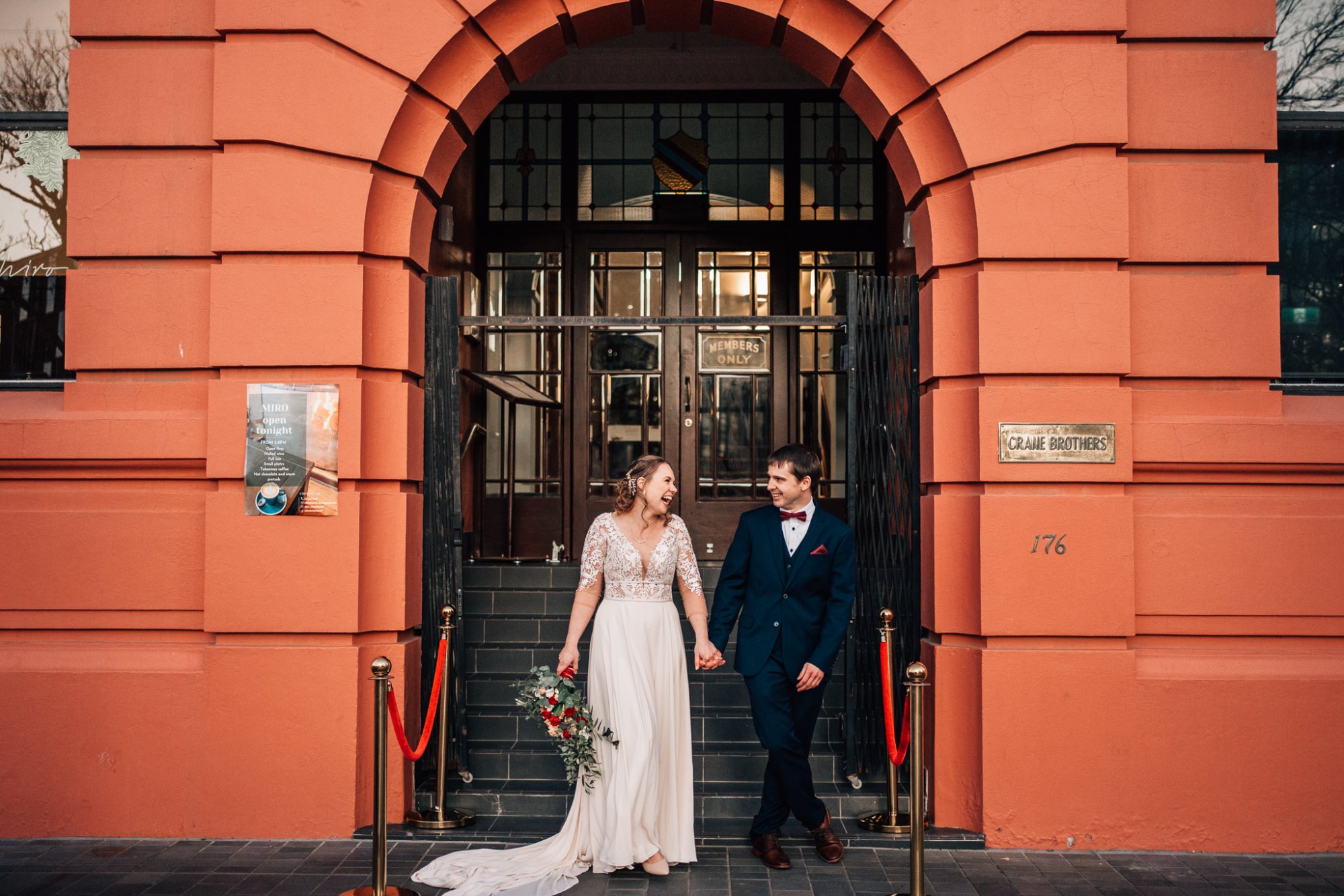 A couple under a stone archway in the city