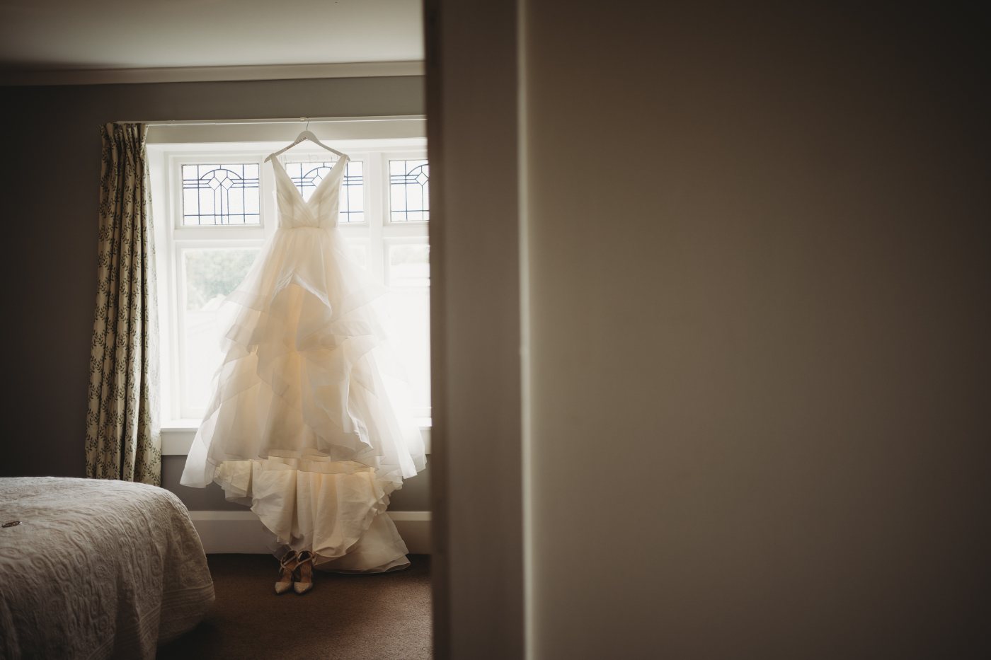 A wedding dress hanging in a window