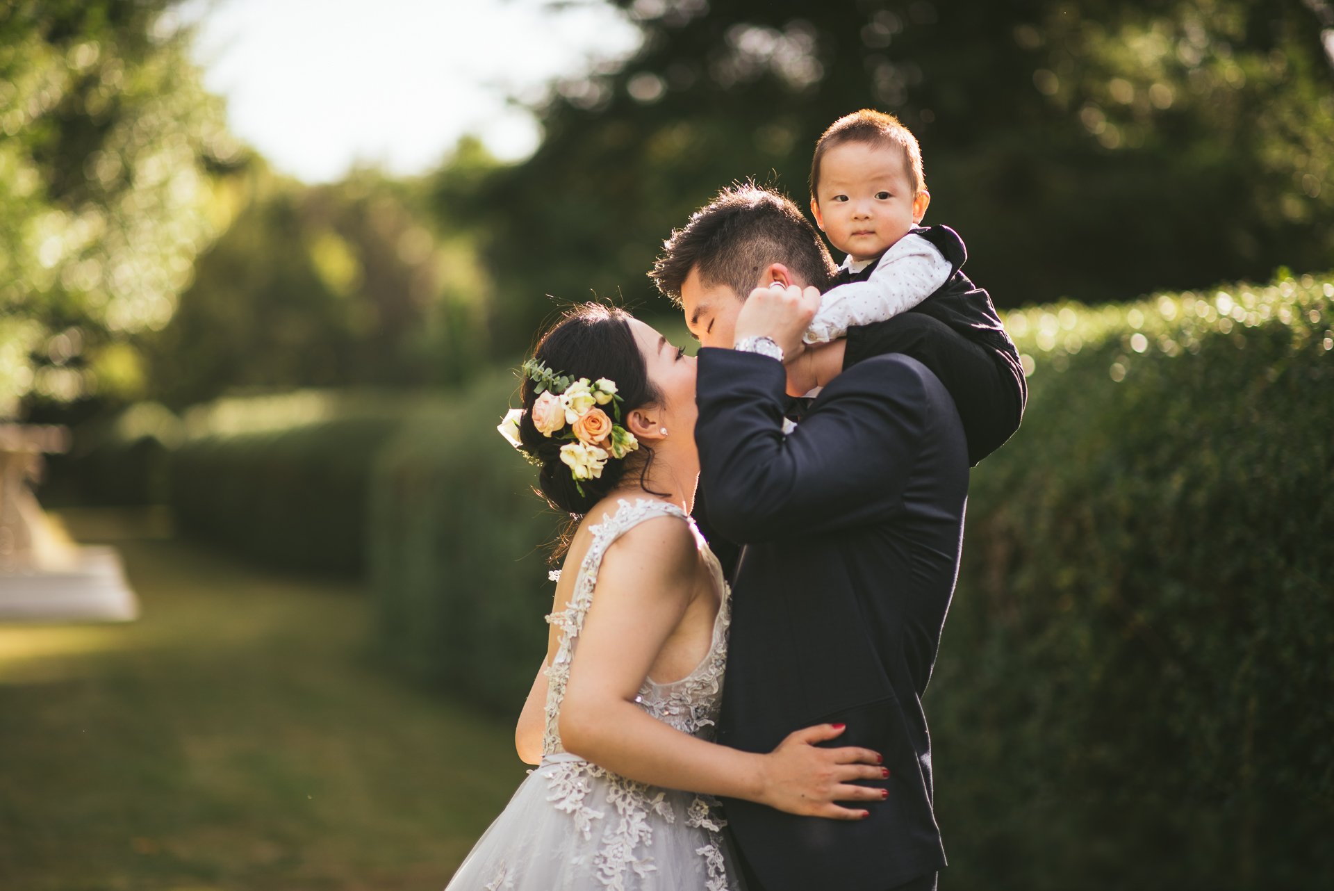 A couple with their baby on their wedding day