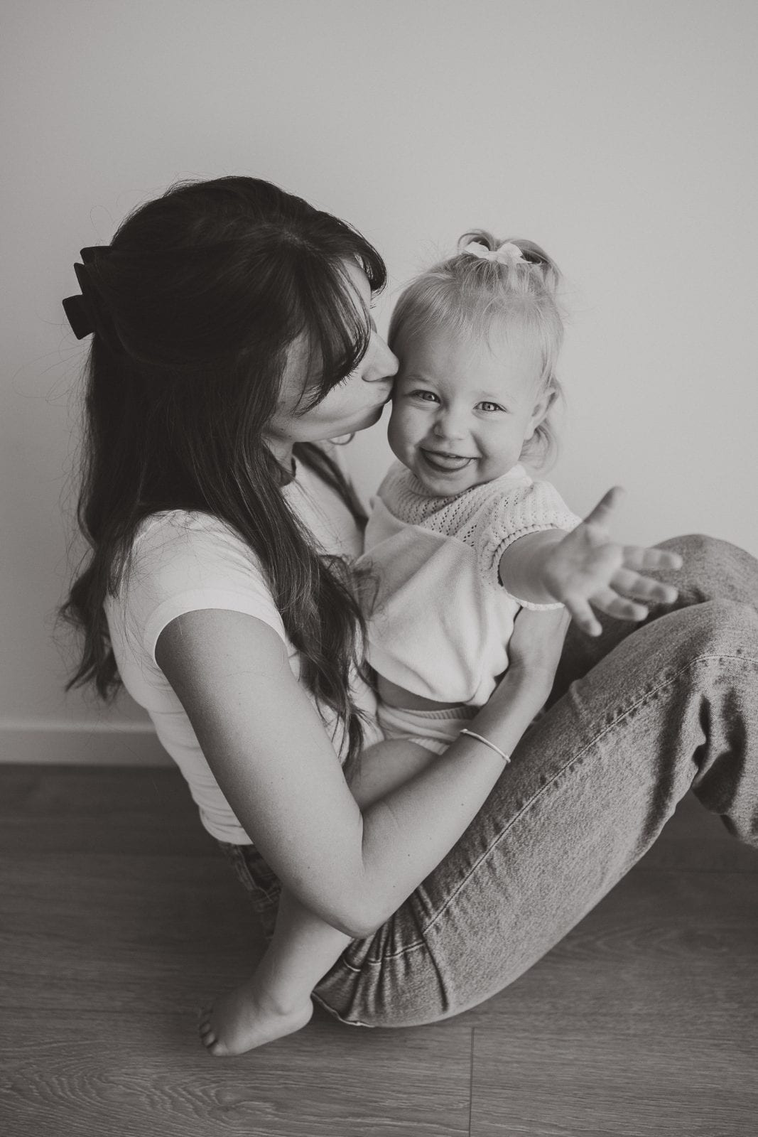 A young family cuddled together during their Little White Studio session